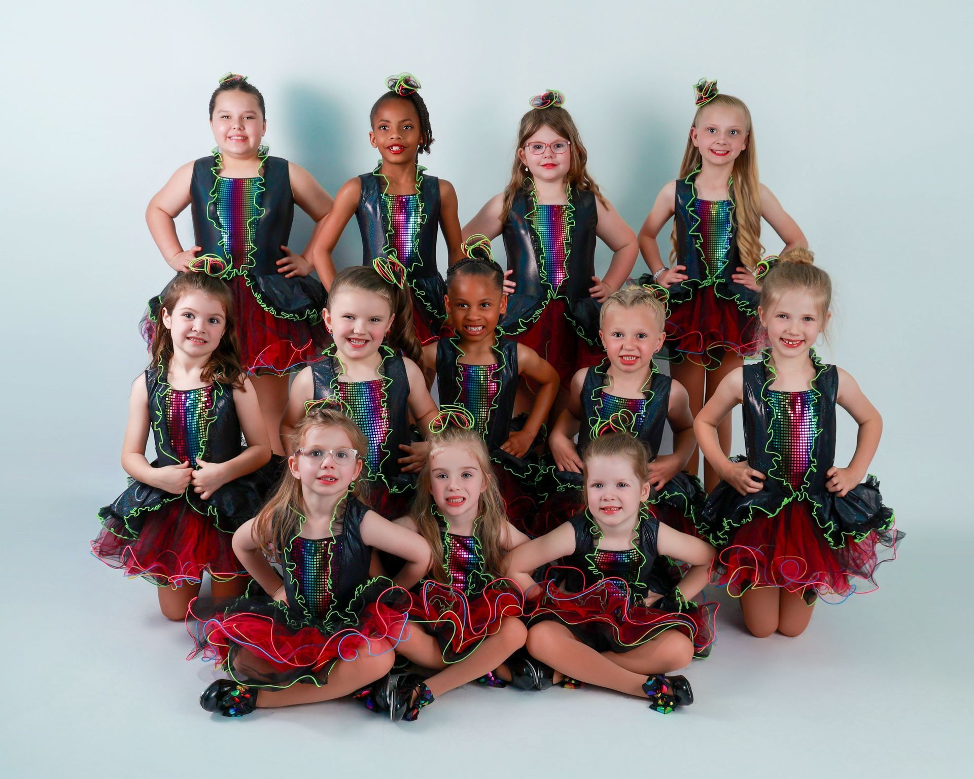 A group of young girls in dance costumes, posing for a photo.