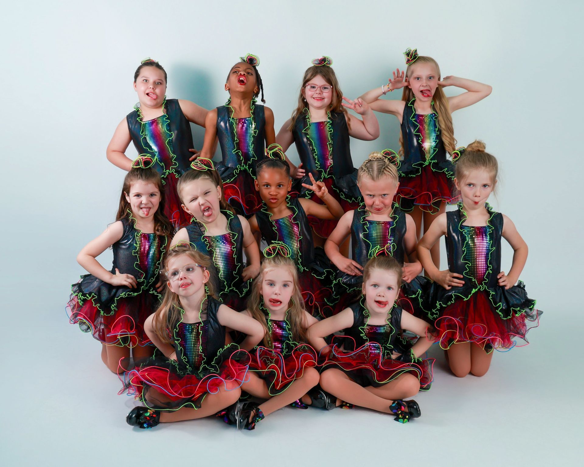 Group of young girls in dance costumes making silly faces.