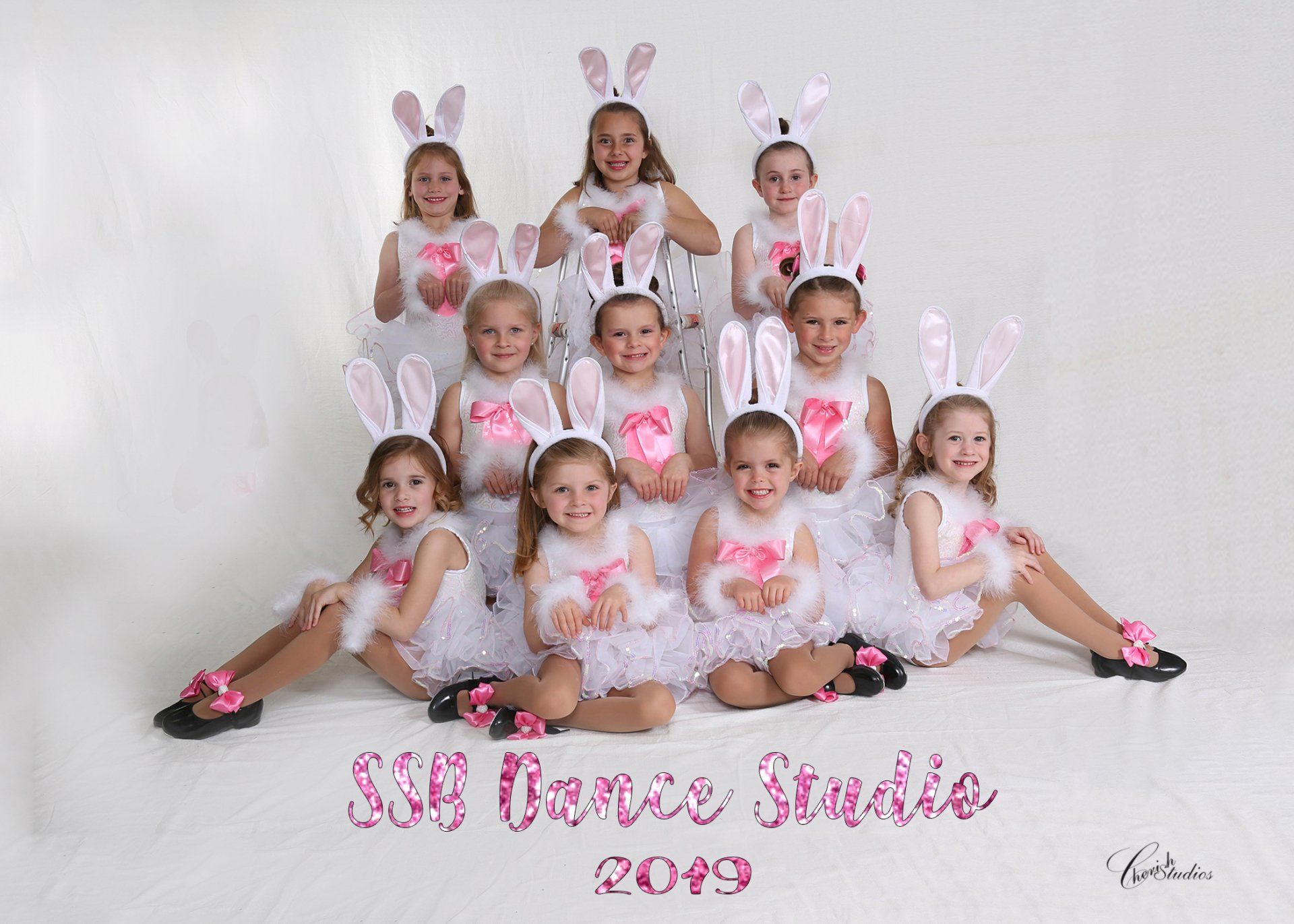 A group of young girls in bunny costumes pose for a dance studio photo, 2019.