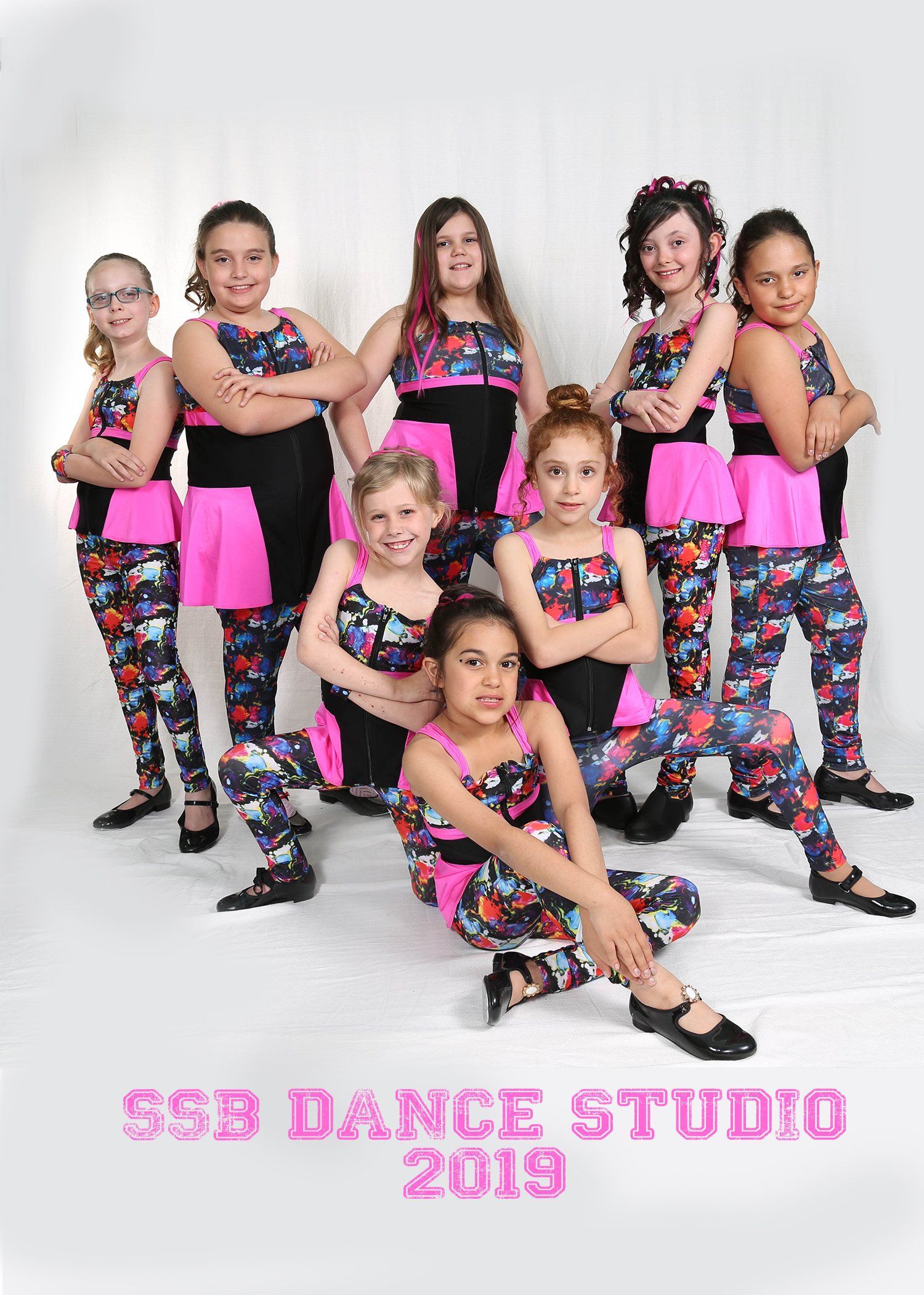 Young dancers in matching outfits pose for a studio group photo.