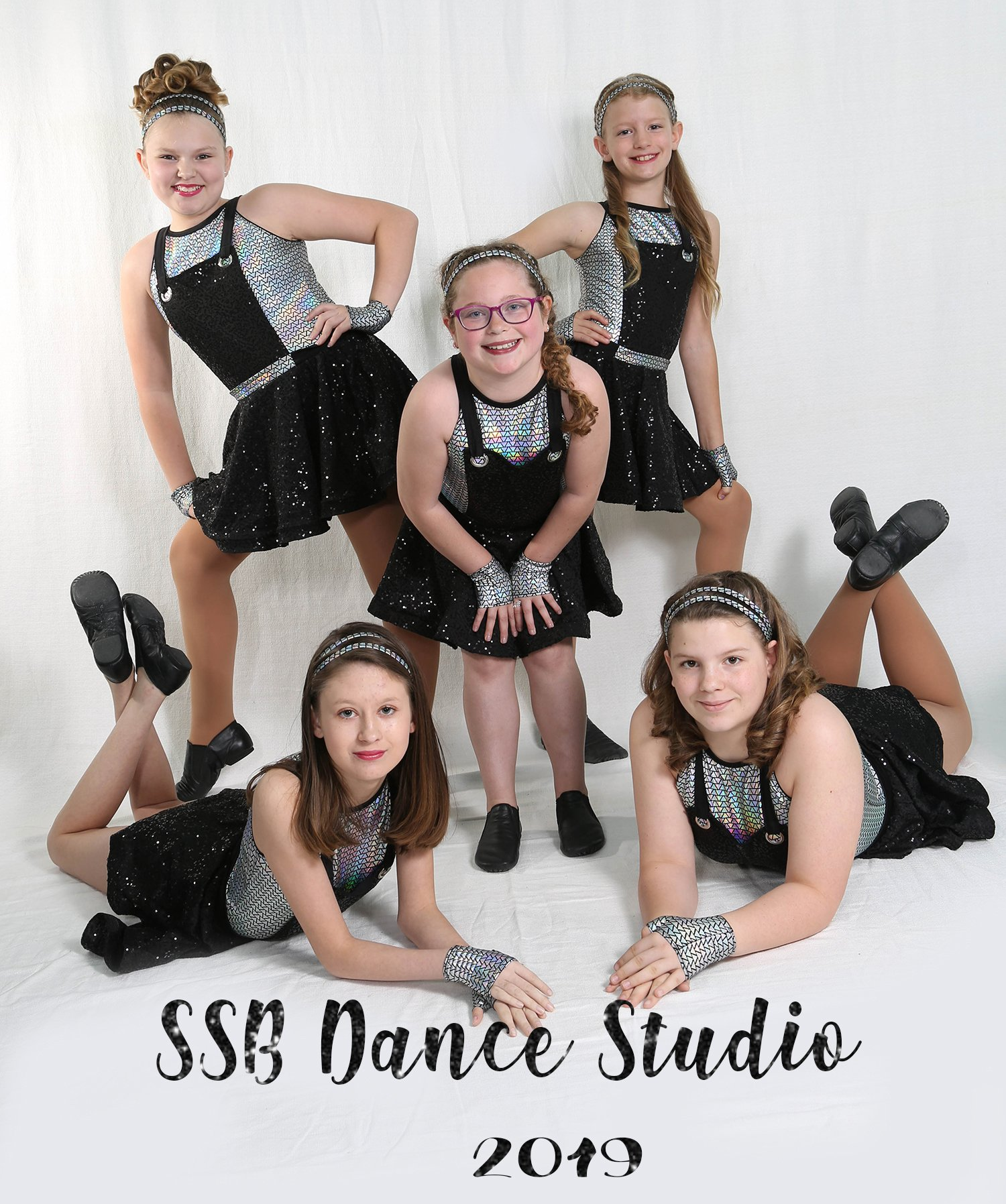 Five young dancers in black outfits, posing in a studio; 