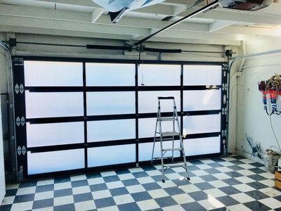 A garage with a checkered floor and a ladder in it.