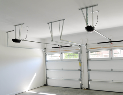 A garage with two garage doors and a ceiling lift.