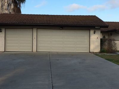 A house with three garage doors and a concrete driveway.