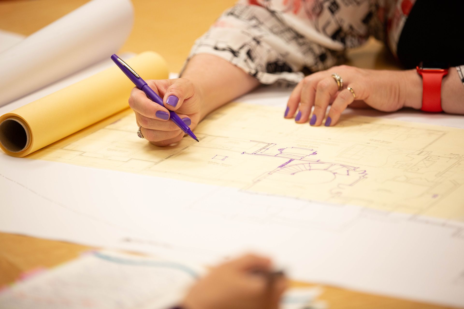 A woman is writing on a piece of paper with a pen.