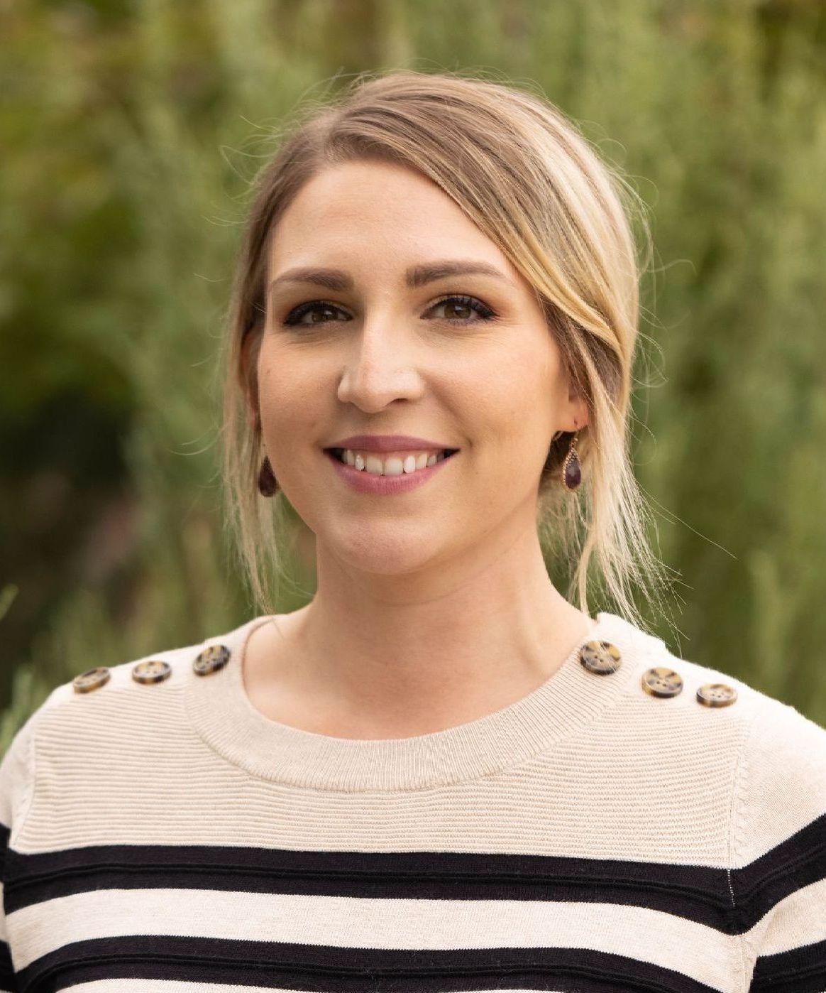 A woman in a floral dress is smiling for the camera.