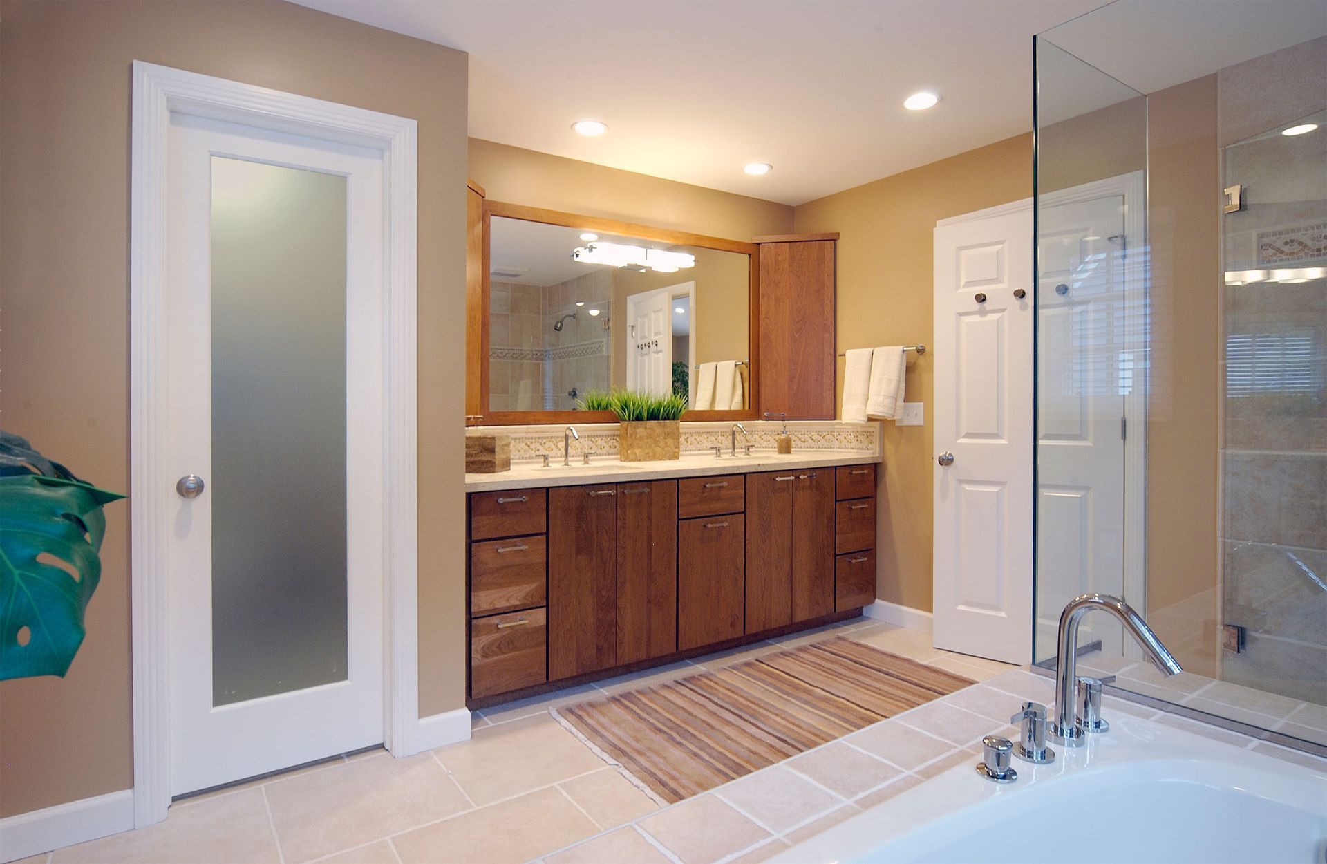 A bathroom with two sinks , a tub and a walk in shower.
