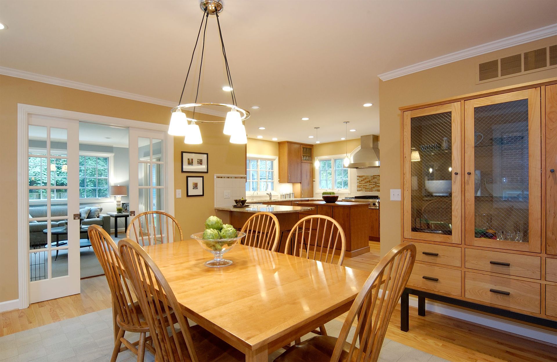 A dining room table with a bowl of apples on it