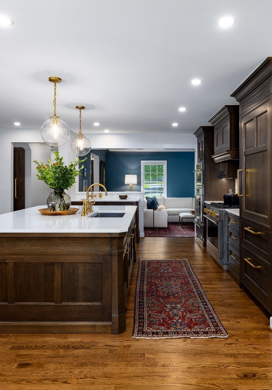 A kitchen with a large island and a rug on the floor.