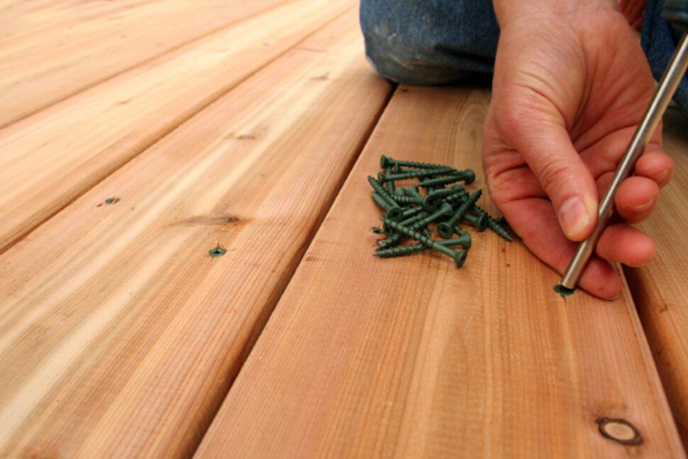 A person is screwing a screw into a piece of wood.