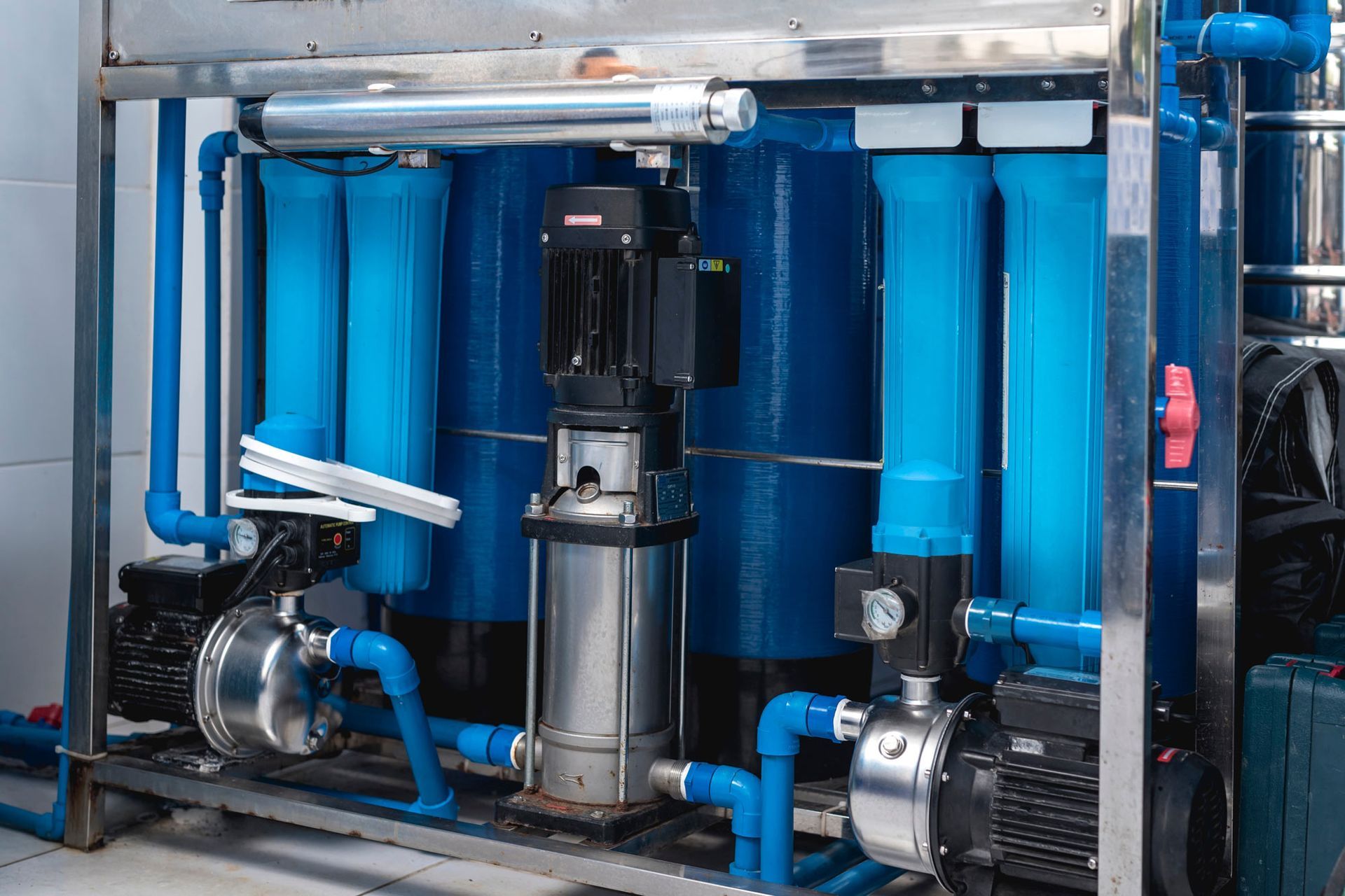 A machine with blue pipes and pumps in a room.