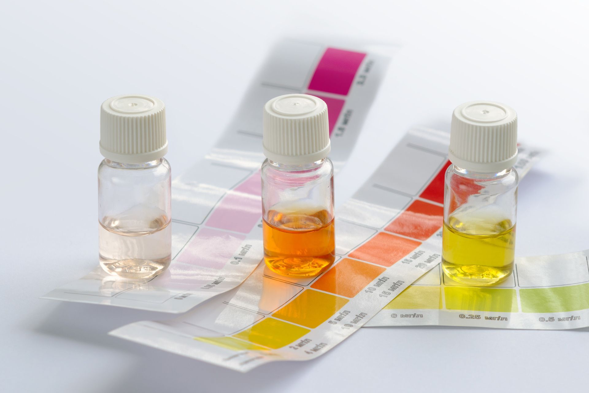 Three small bottles filled with different colored liquids are sitting next to each other on a table.