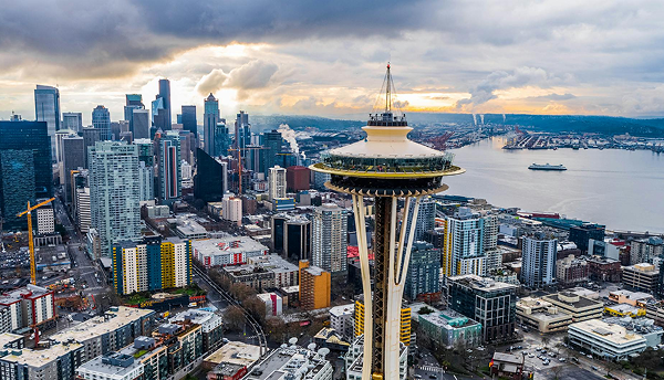 Seattle skyline with Space Needle; overcast sky, buildings, water visible.