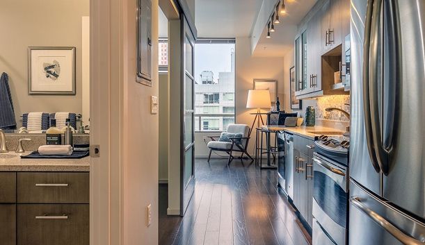 Modern apartment interior with kitchen, bathroom, and living area visible.