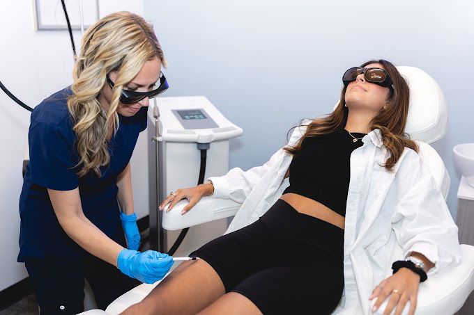 A woman is getting a laser hair removal treatment on her leg.