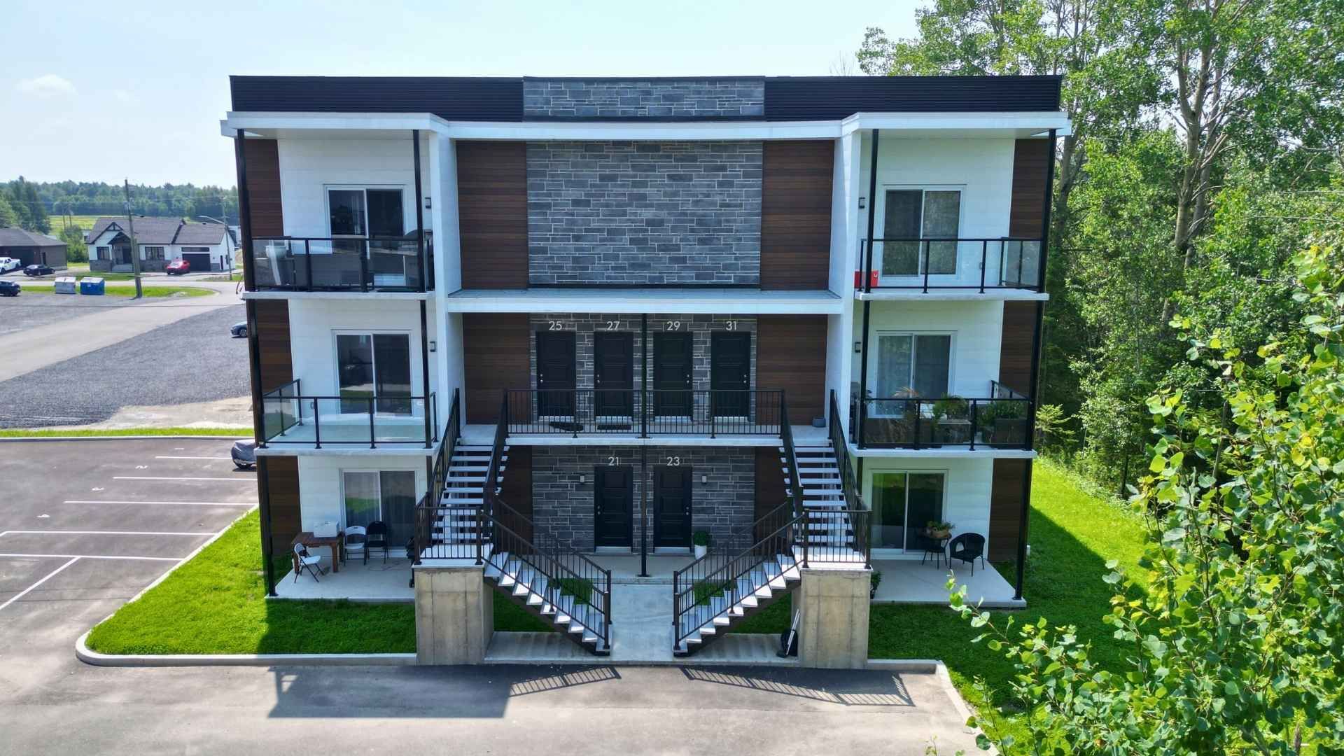 un grand immeuble avec des voitures garées devant.