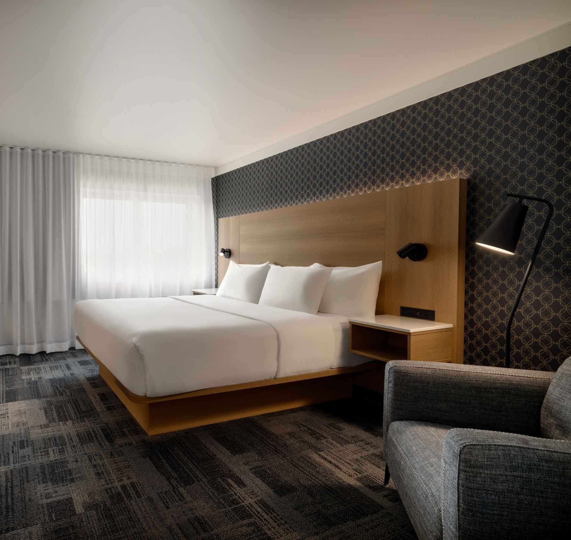 Une chambre d'hôtel avec un lit king size et une chaise