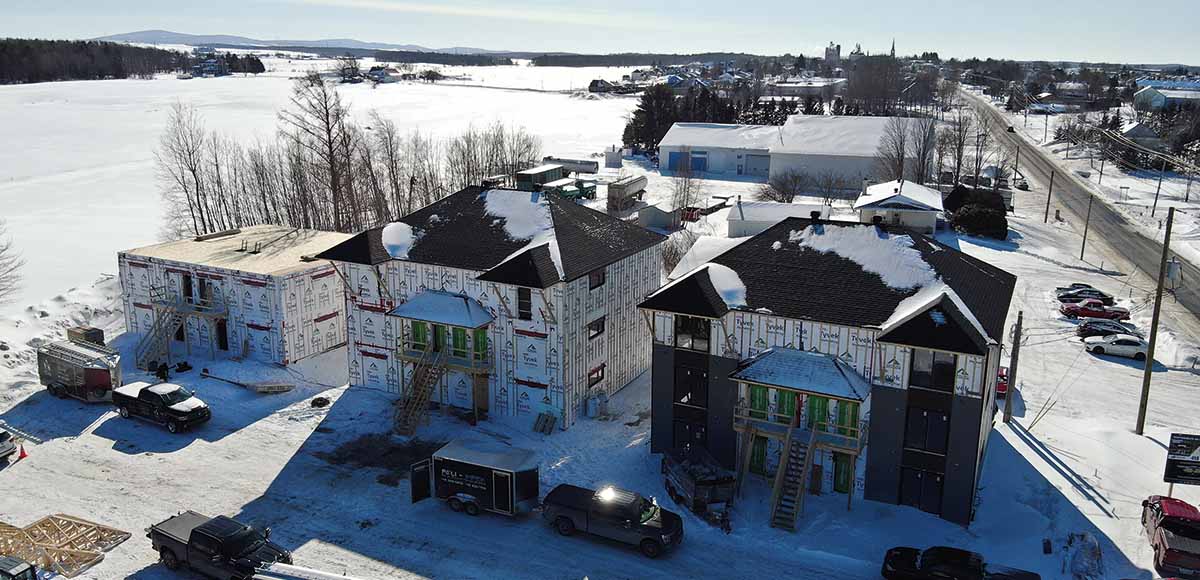 Une vue aérienne de plusieurs bâtiments d'habitations en construction dans la neige.