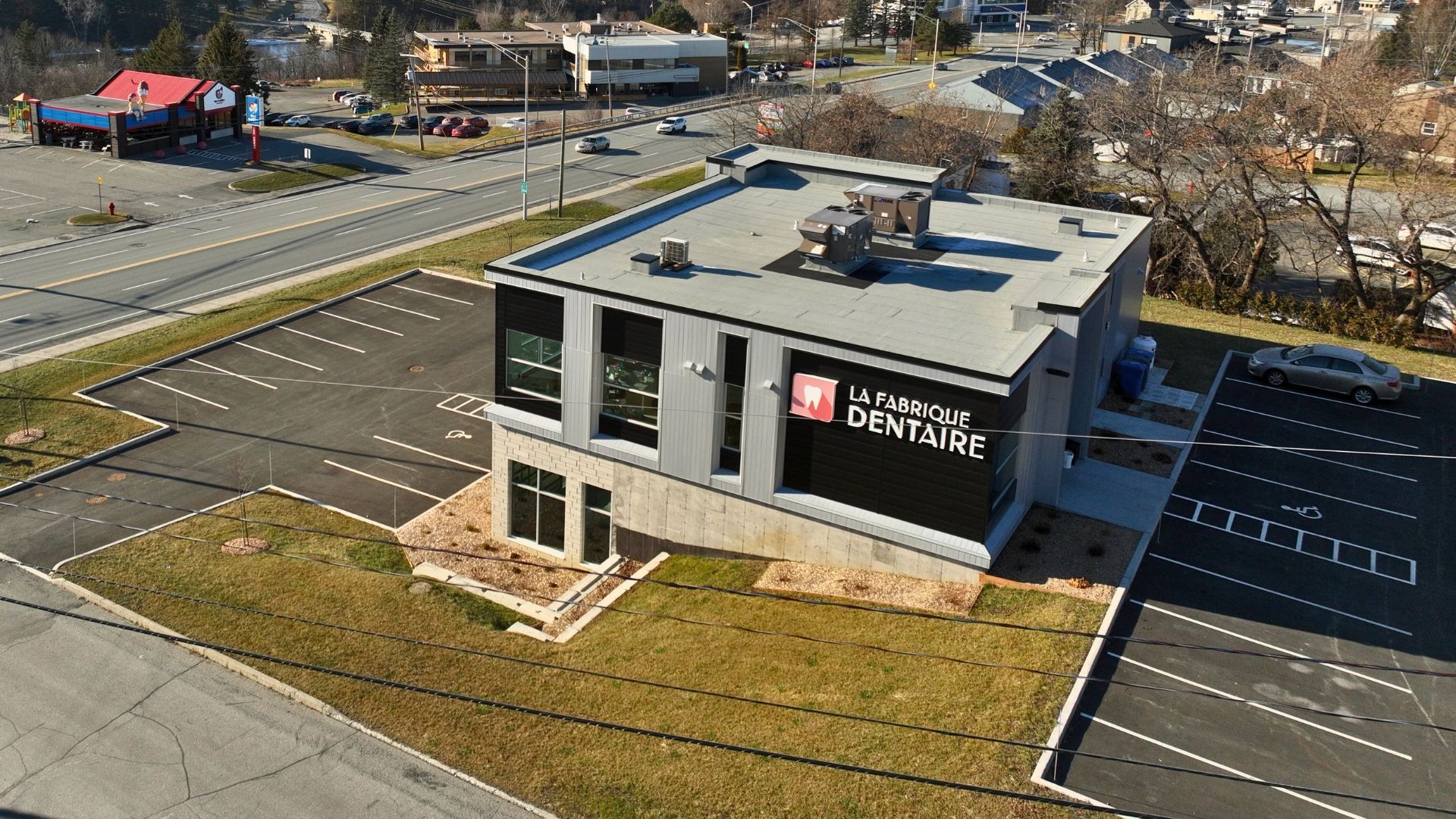 Bâtiment commercial moderne abritant un cabinet dentaire, avec parking.