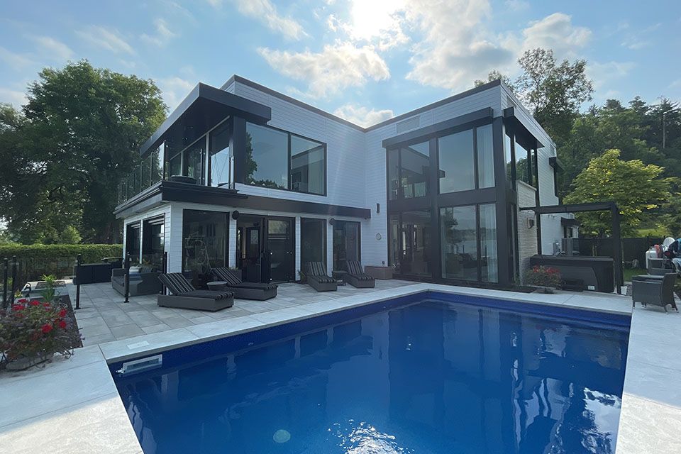 Une grande maison blanche avec une grande piscine devant.