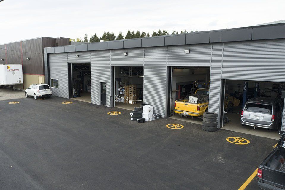 beaucoup de voitures sont garées devant un garage.