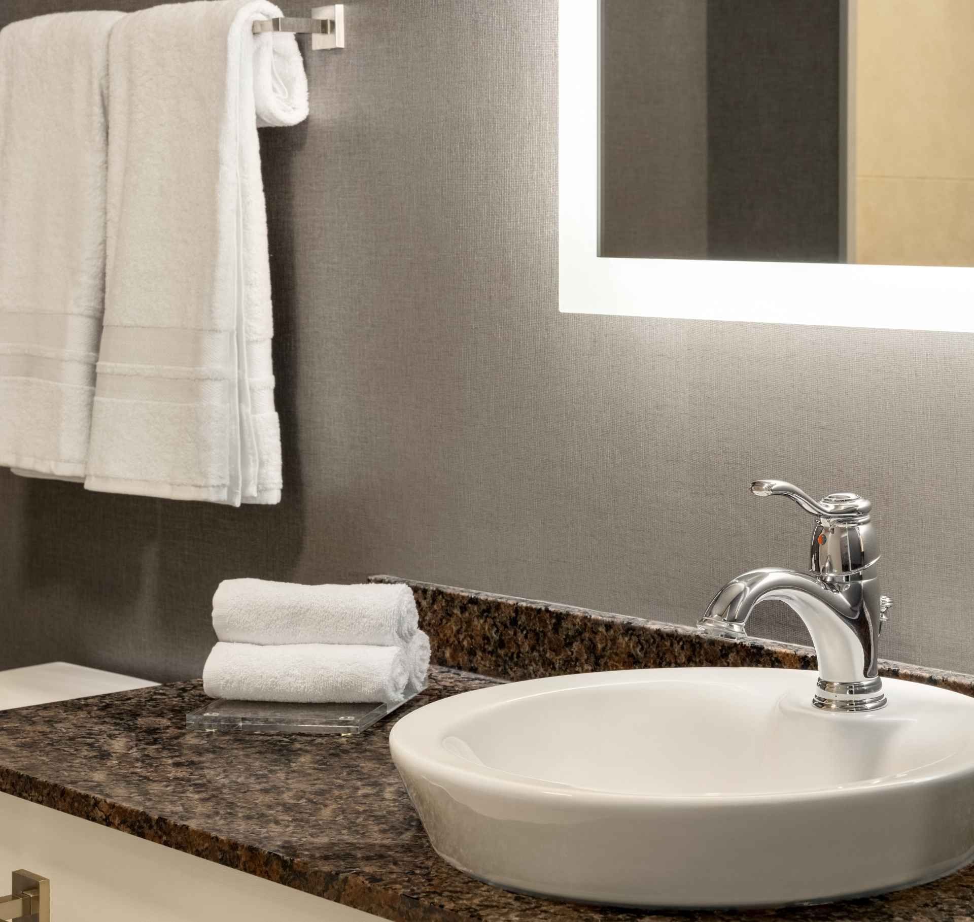 Une salle de bain avec un lavabo et des serviettes sur le comptoir