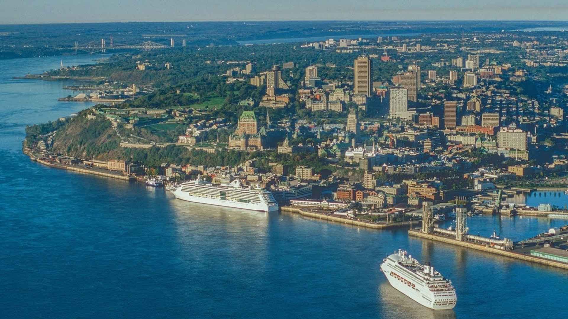 Vue aérienne de la ville de Québec avec des navires de croisière, une eau bleue.