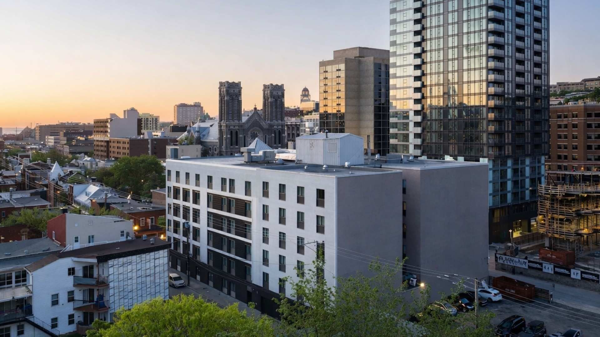 Paysage urbain avec des bâtiments de hauteurs variées et un hôtel au centre de l'image.
