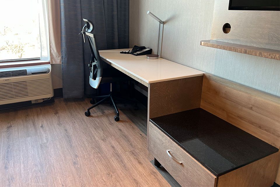 Une chambre d'hôtel avec un bureau, une chaise et une télévision.