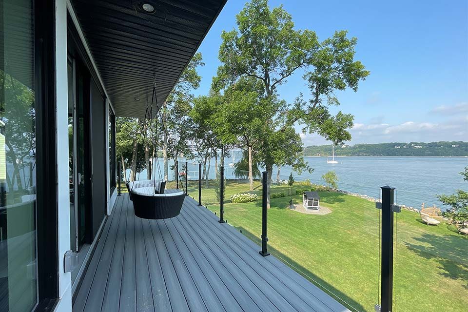 Une grande terrasse avec balançoire et vue sur un lac.
