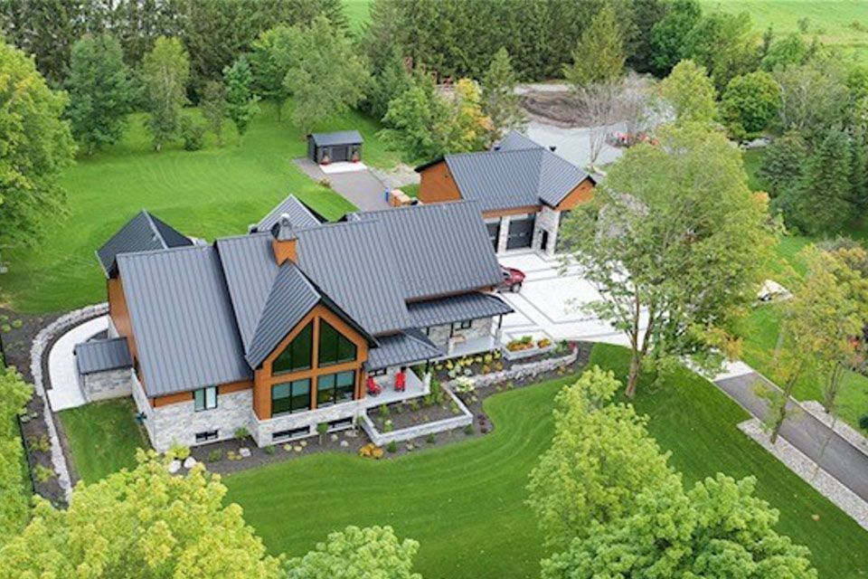 Une vue aérienne d'une grande maison entourée d'arbres et d'herbe.