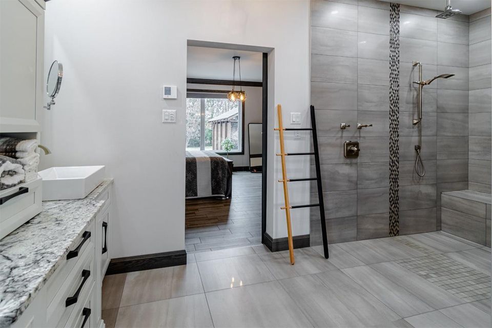 Une salle d'eau avec douche à l'italienne, lavabo et échelle.