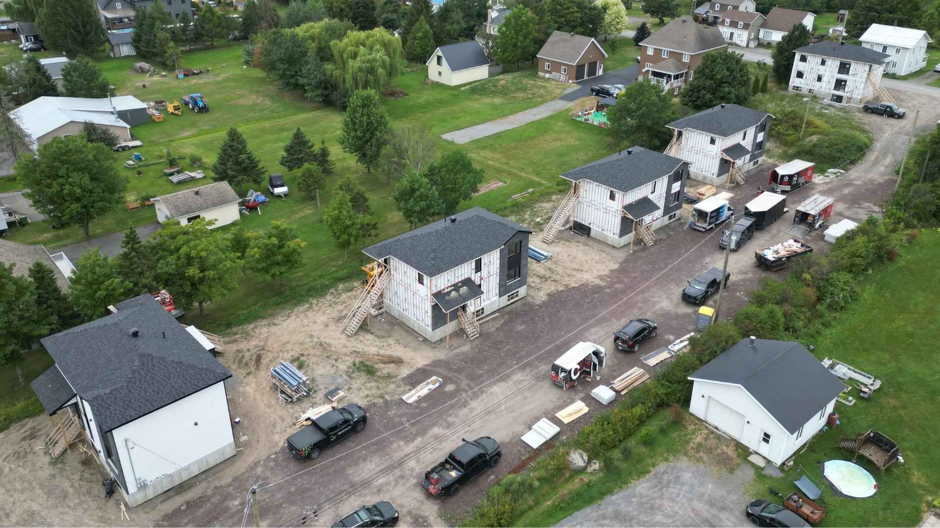 Vue aérienne de triplex en construction avec des engins de chantier.