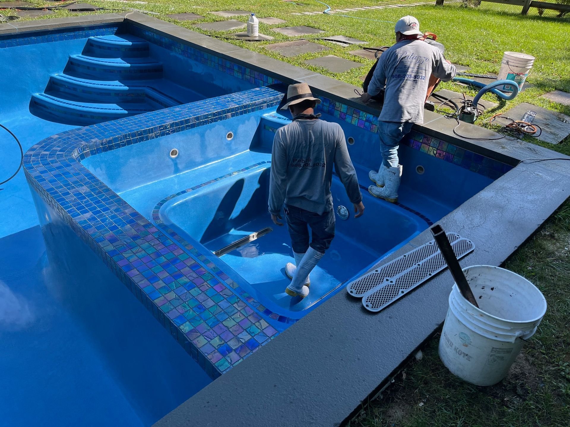 Two men are working on a swimming pool.