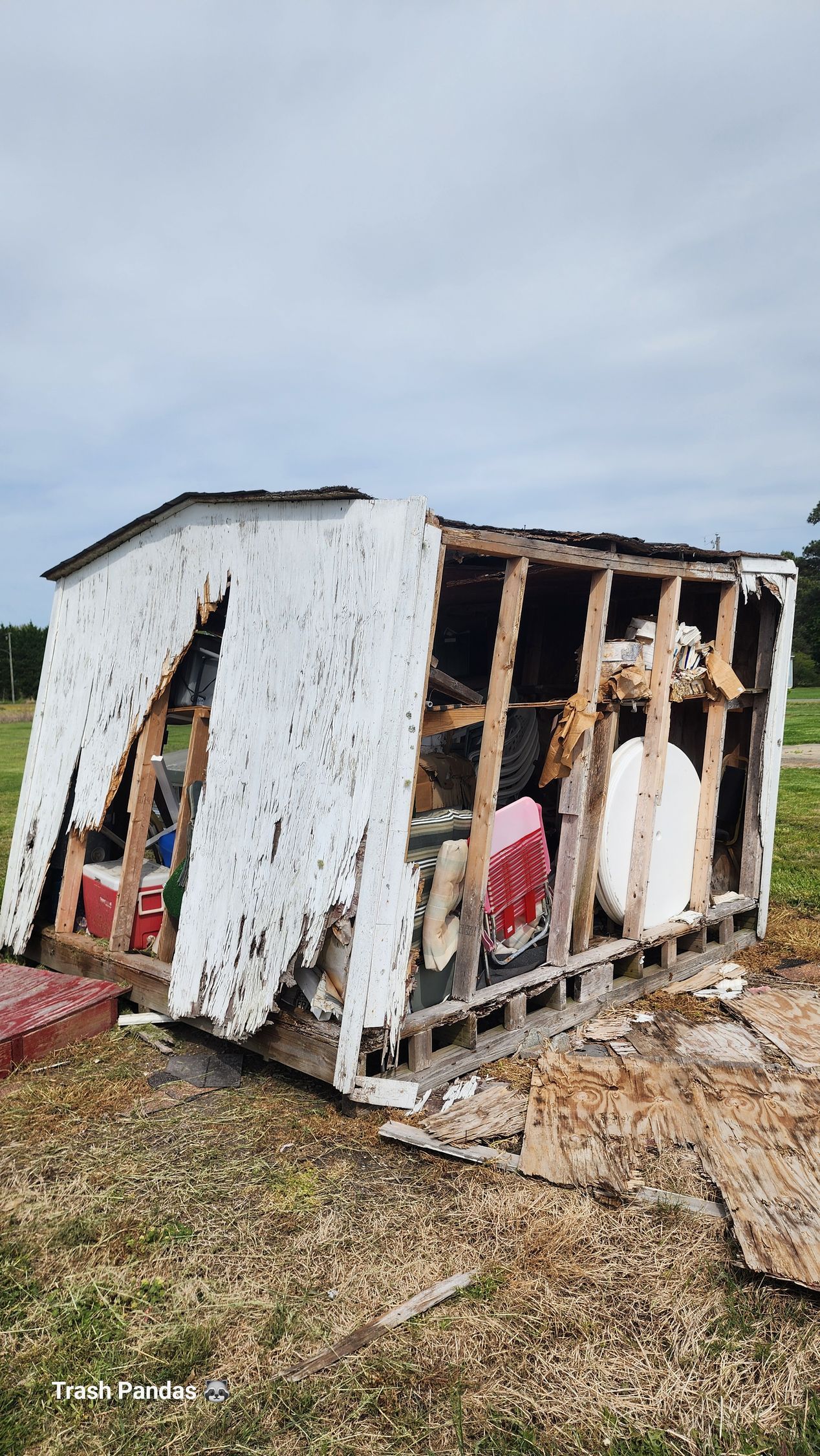 A shovel is laying on the ground next to a black bucket.