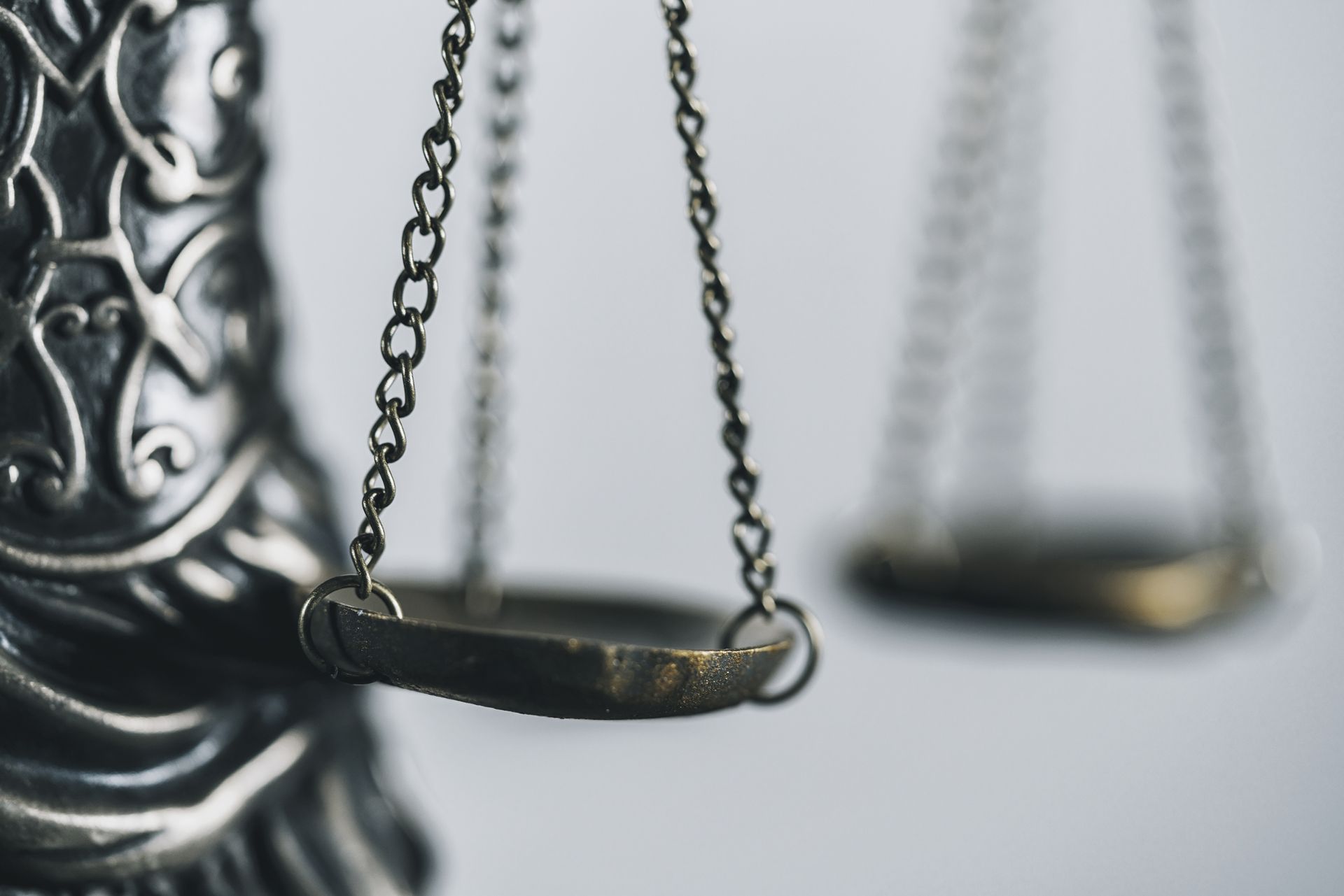 A close up of a scale of justice on a white background.