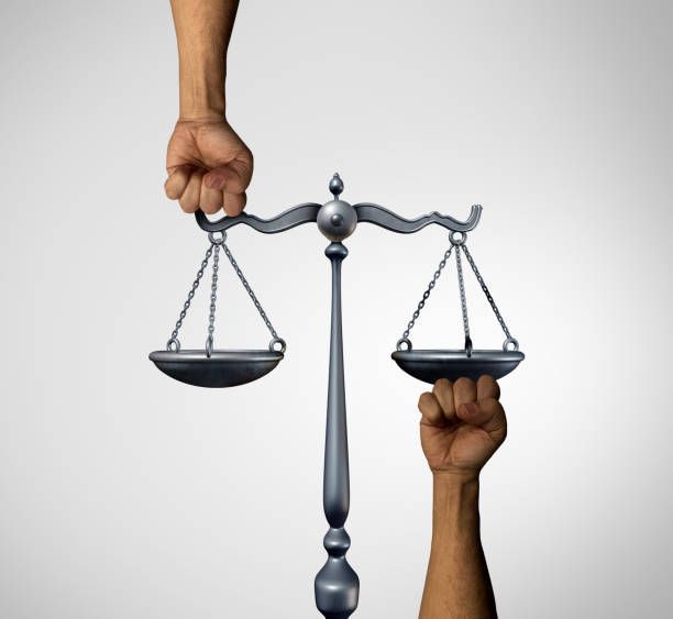Two hands are holding up a scale of justice