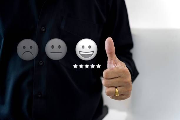 A man is giving a thumbs up in front of a smiley face.