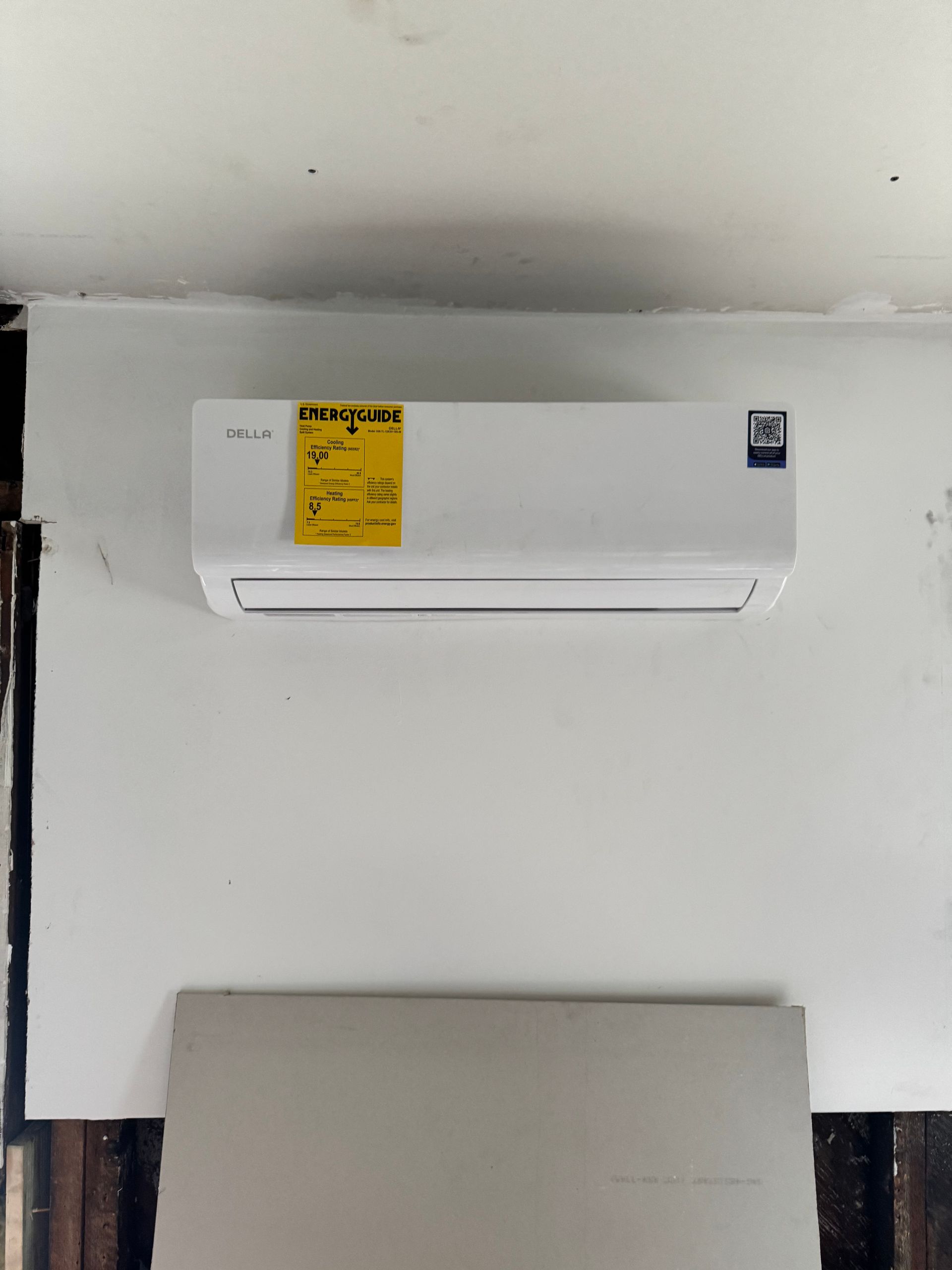 White wall-mounted air conditioner with a yellow energy label.