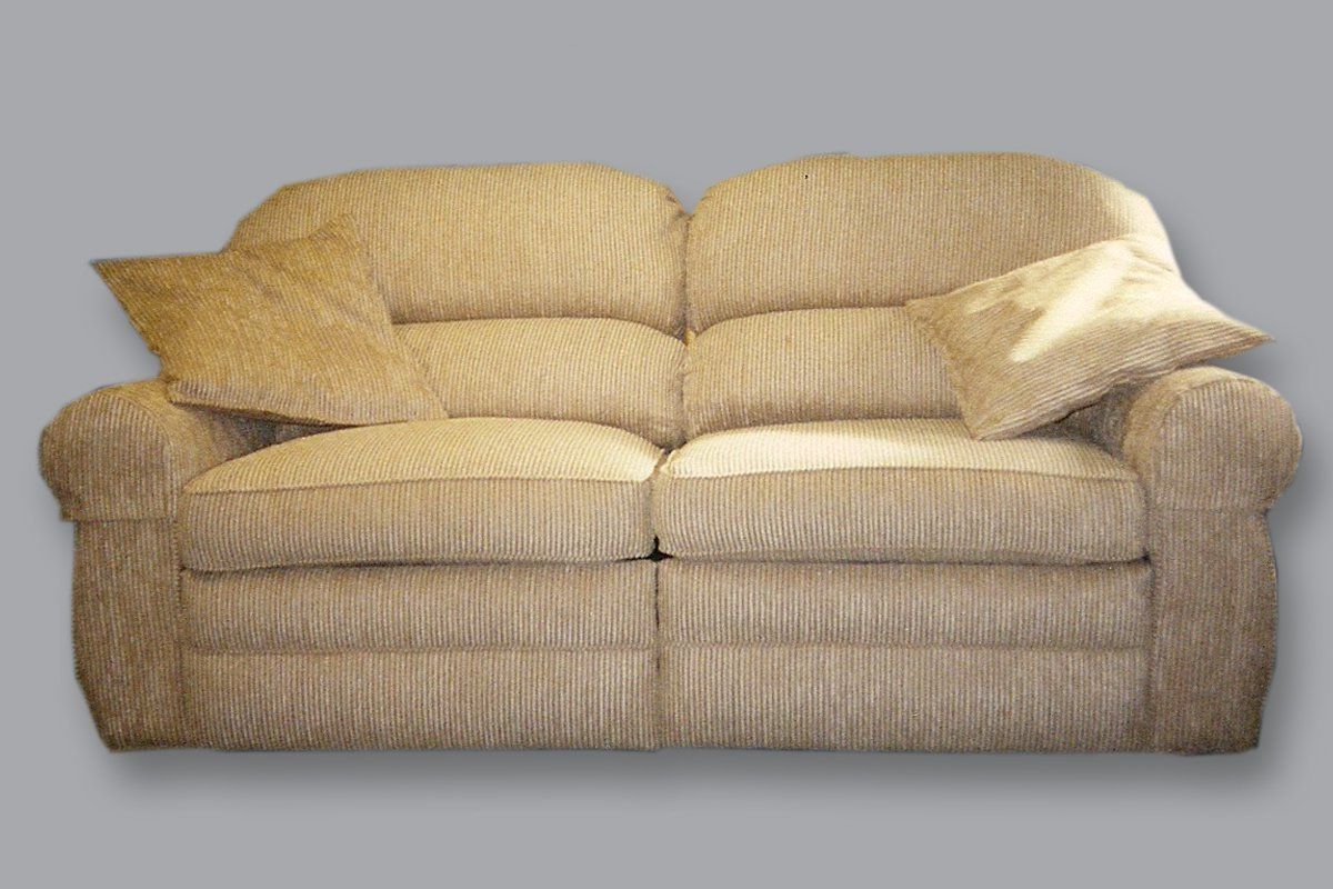 A beige two-seater sofa with two matching throw pillows against a plain gray background.