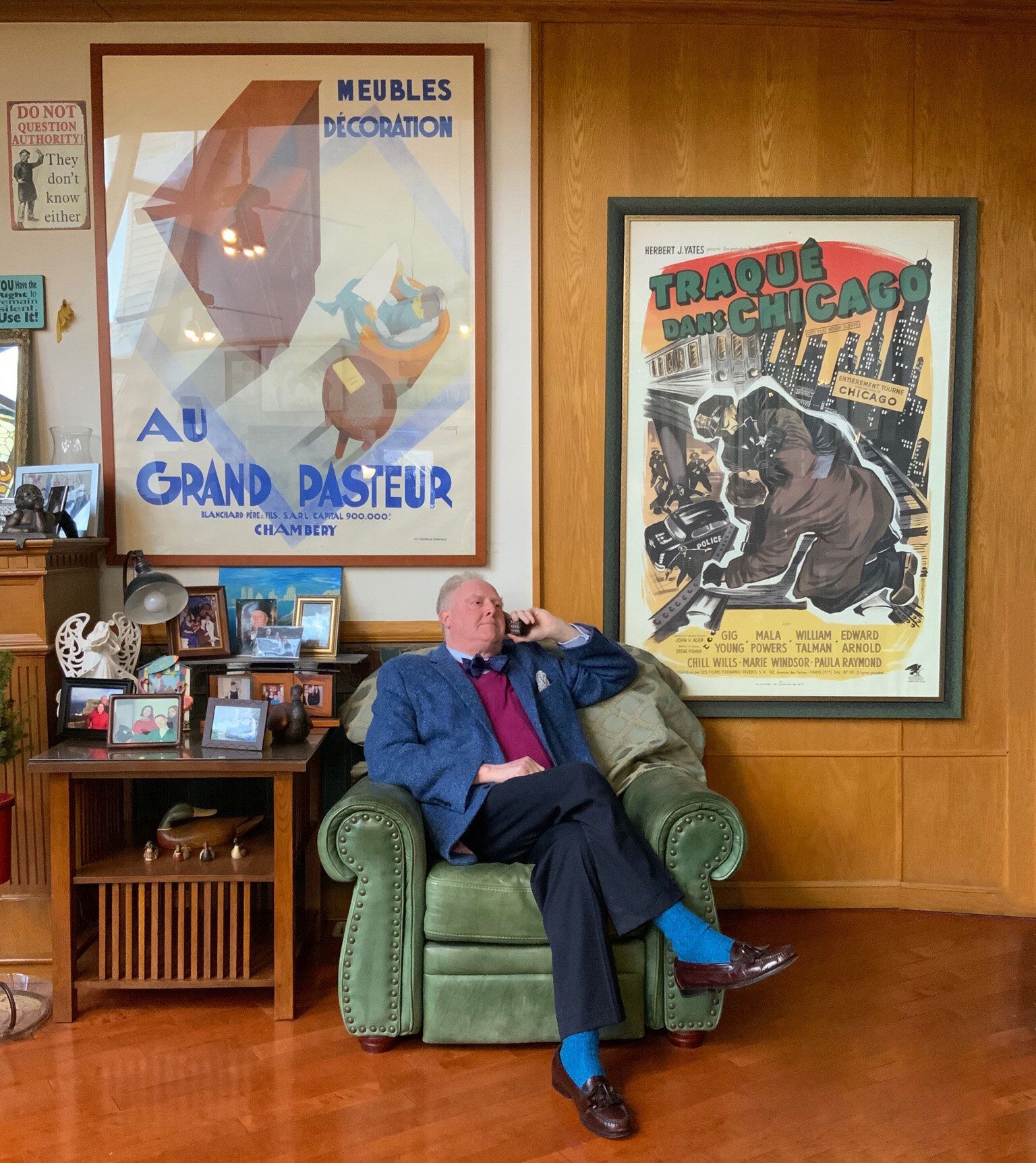 A man sits in a chair in front of a poster that says grand pasteur