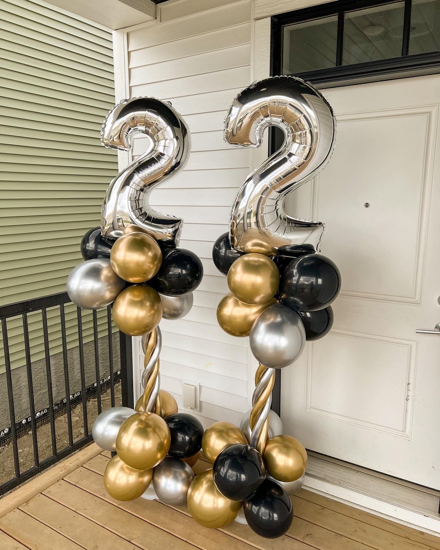 A bunch of balloons with numbers on them on a porch.