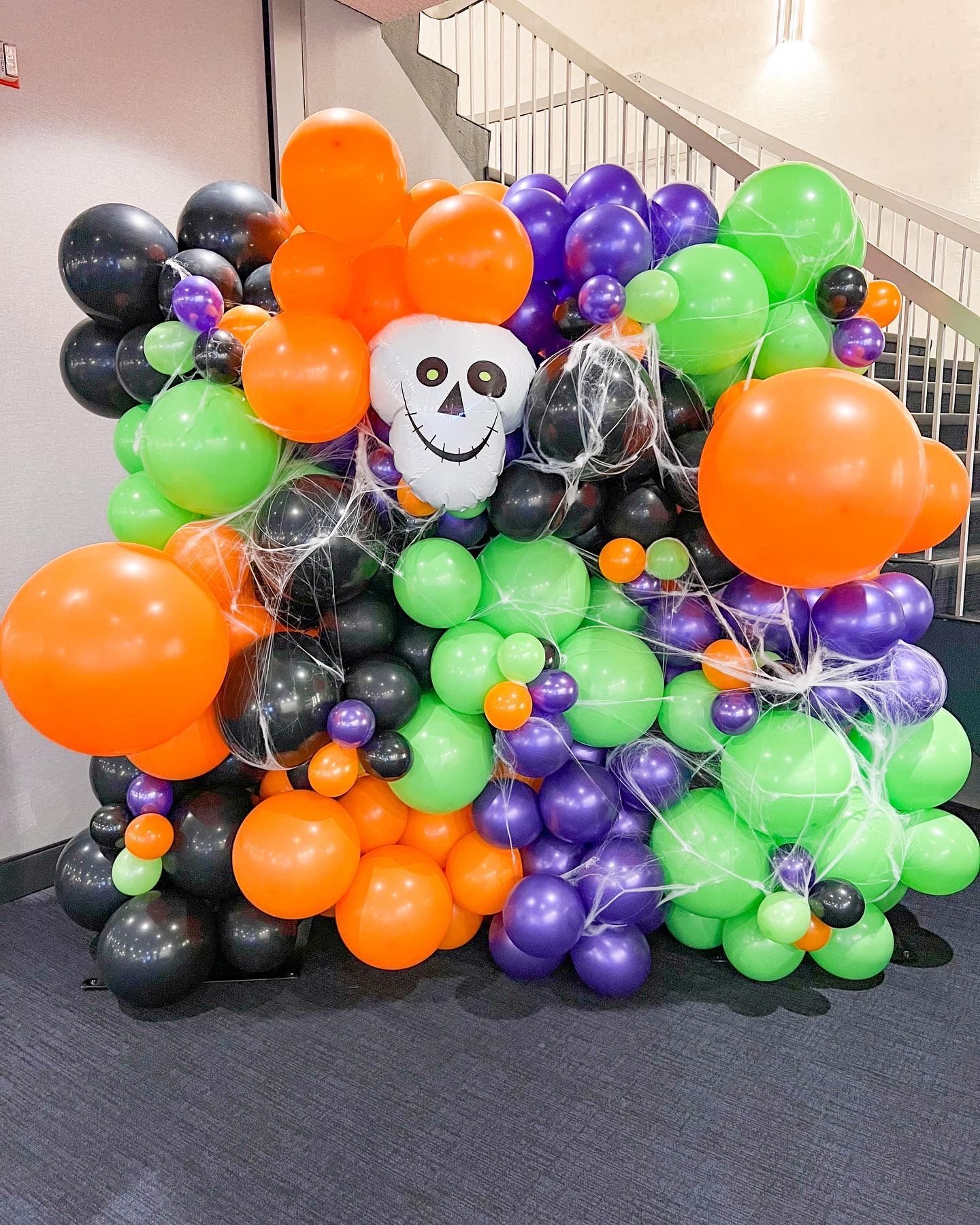 A bunch of halloween balloons are sitting on the floor.