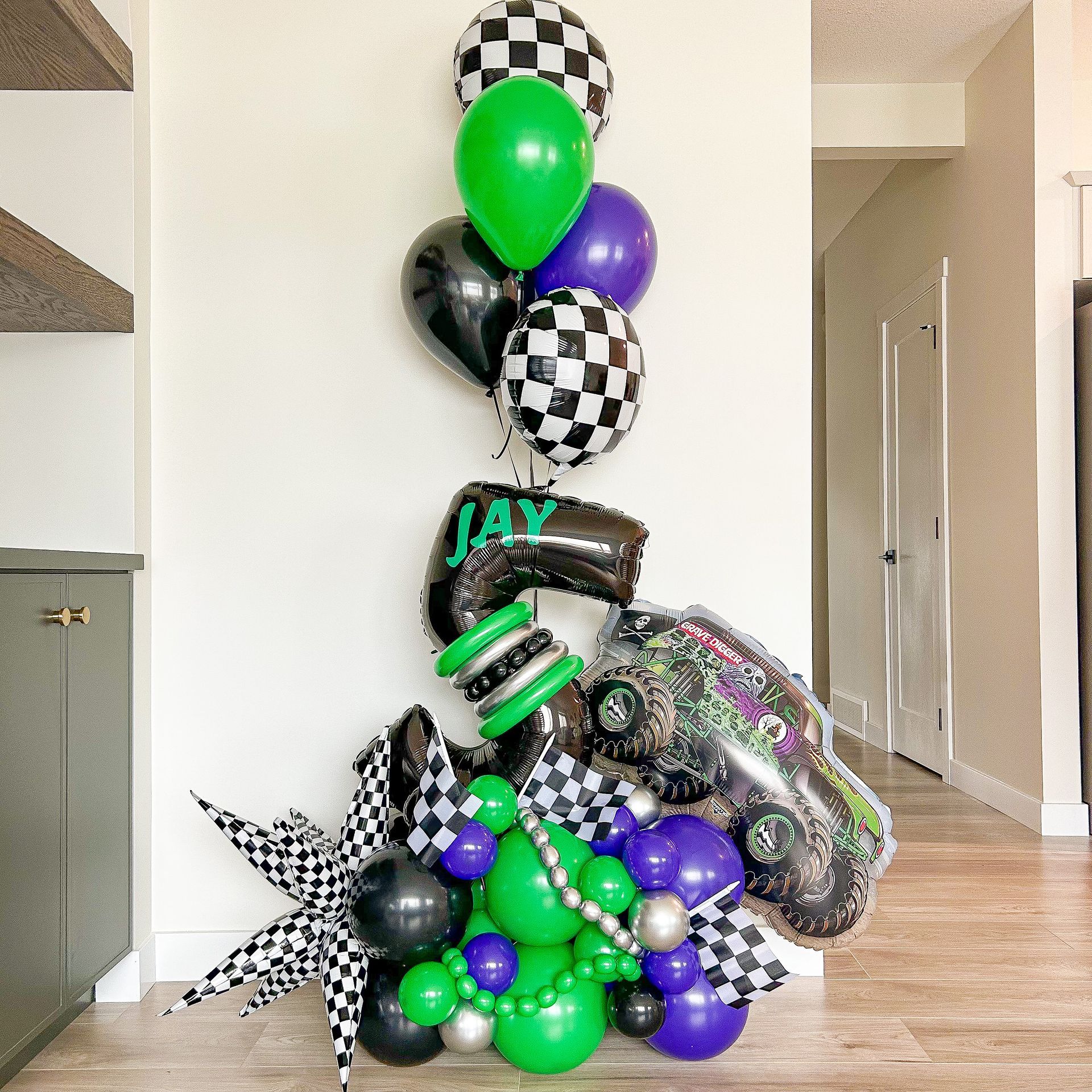 A bunch of balloons are sitting on a wooden floor.