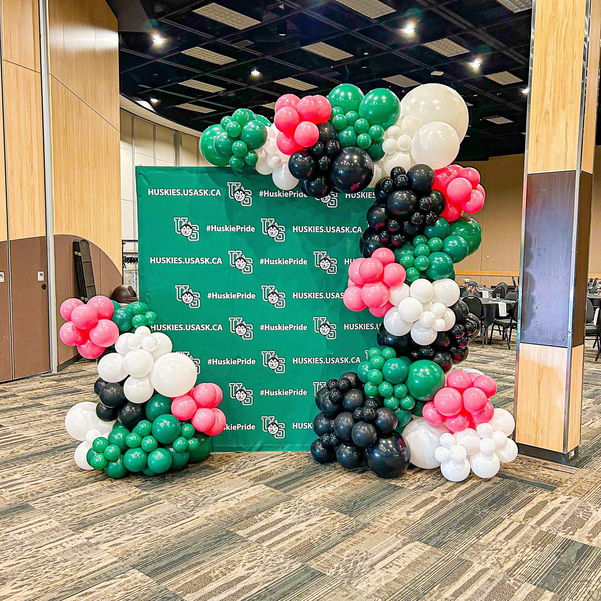 A bunch of balloons are sitting on a wall in a room.