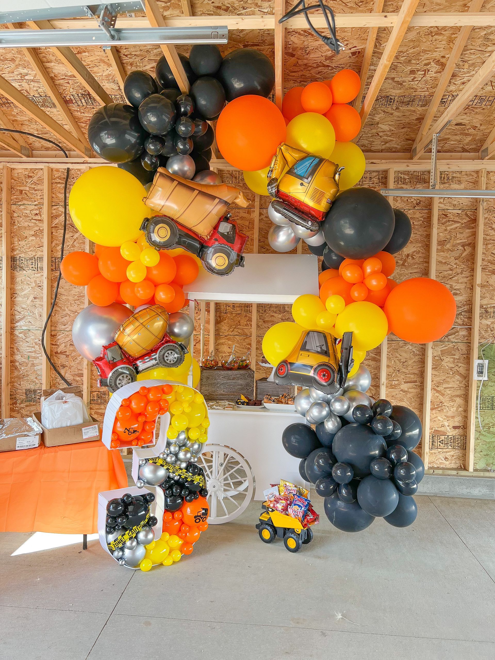 A bunch of balloons are hanging from the ceiling in a garage.