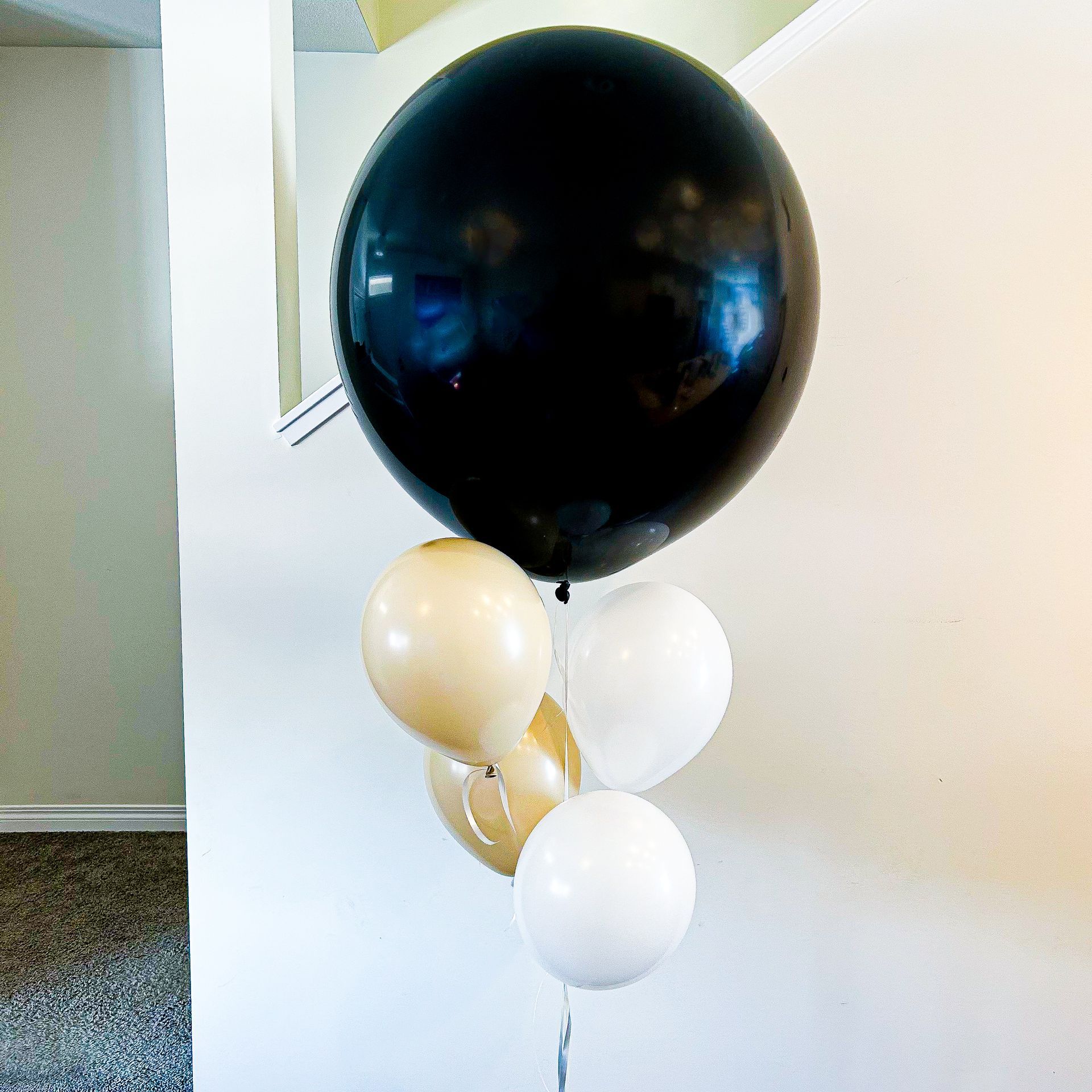 A bunch of balloons including a large black balloon