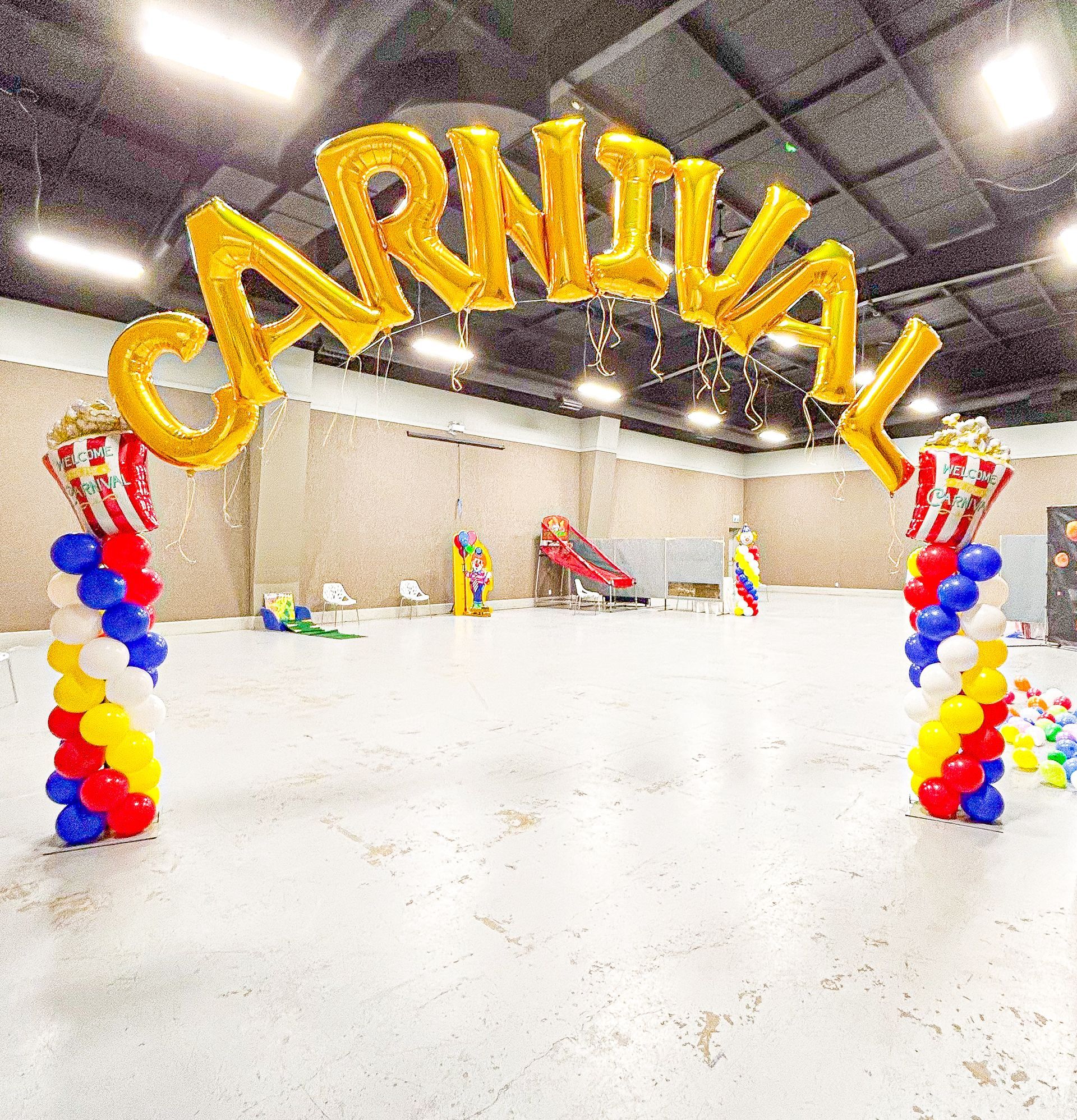 A large room filled with balloons and a sign that says carnival.