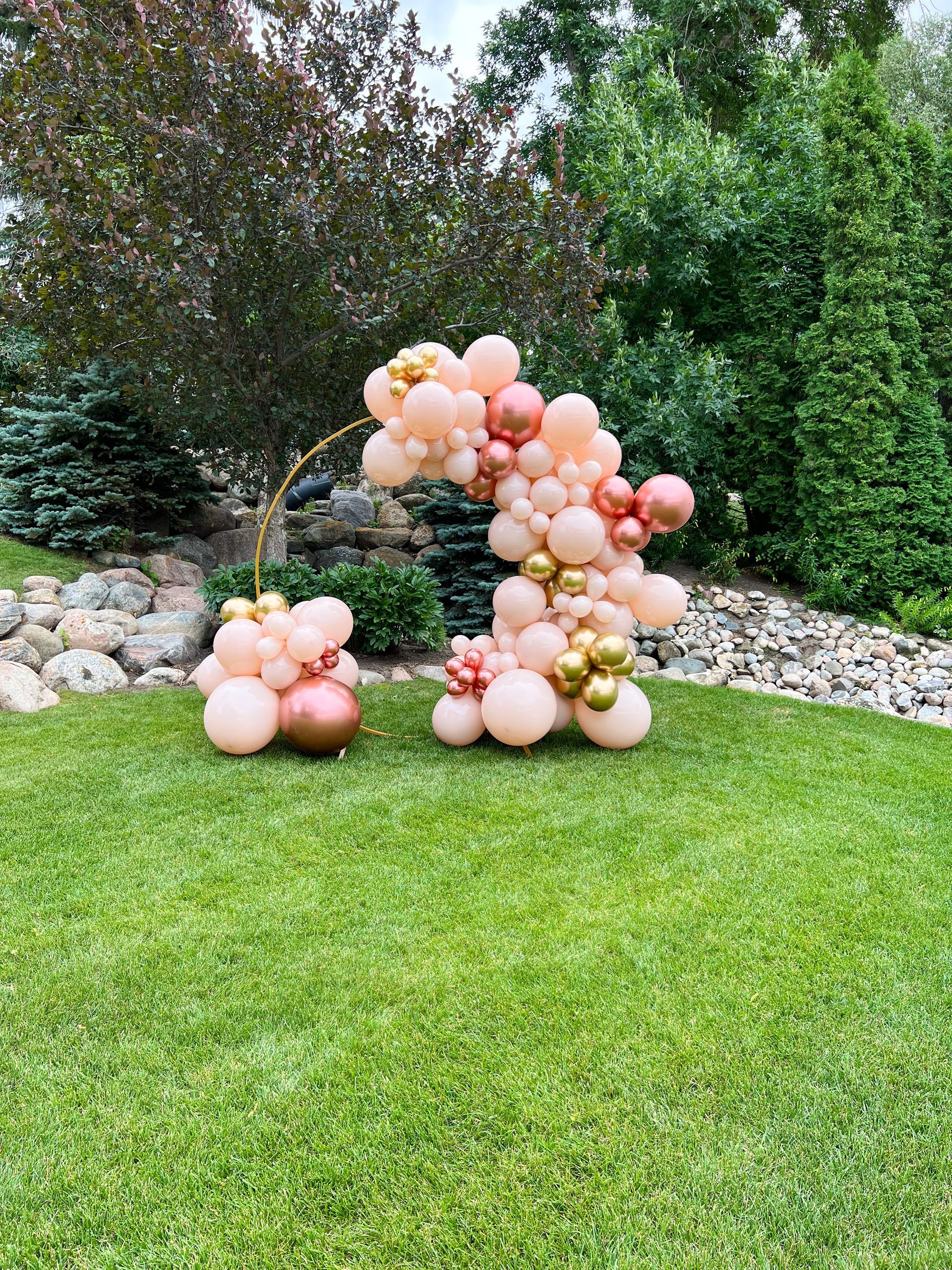 A bunch of balloons are sitting on top of a lush green field.