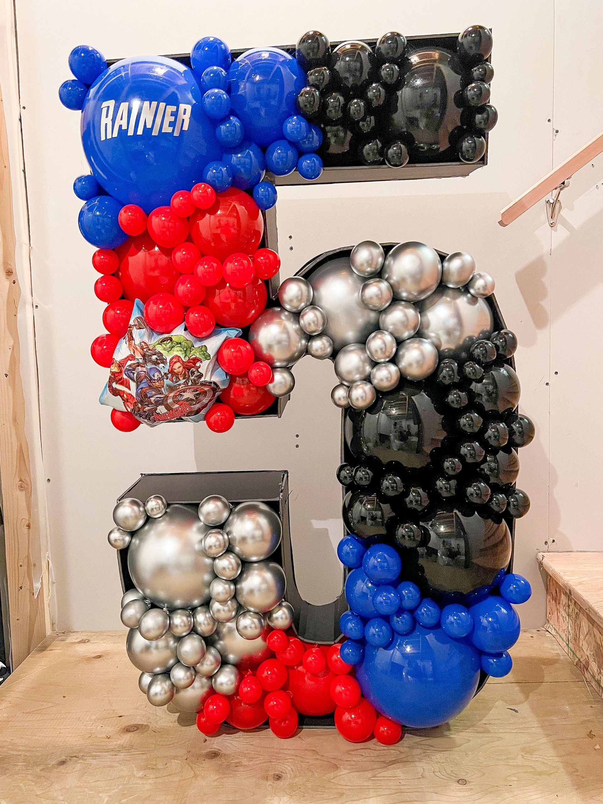 A large number 5 made of balloons is sitting on a table.